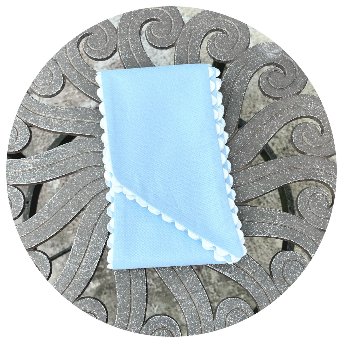 Light blue fabric with white trim on a decorative metal surface