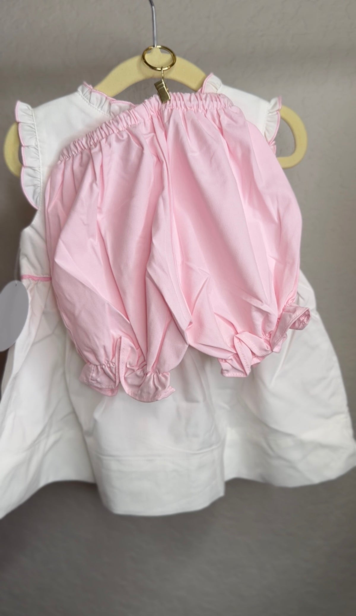 Pink bloomers hanging from a hanger