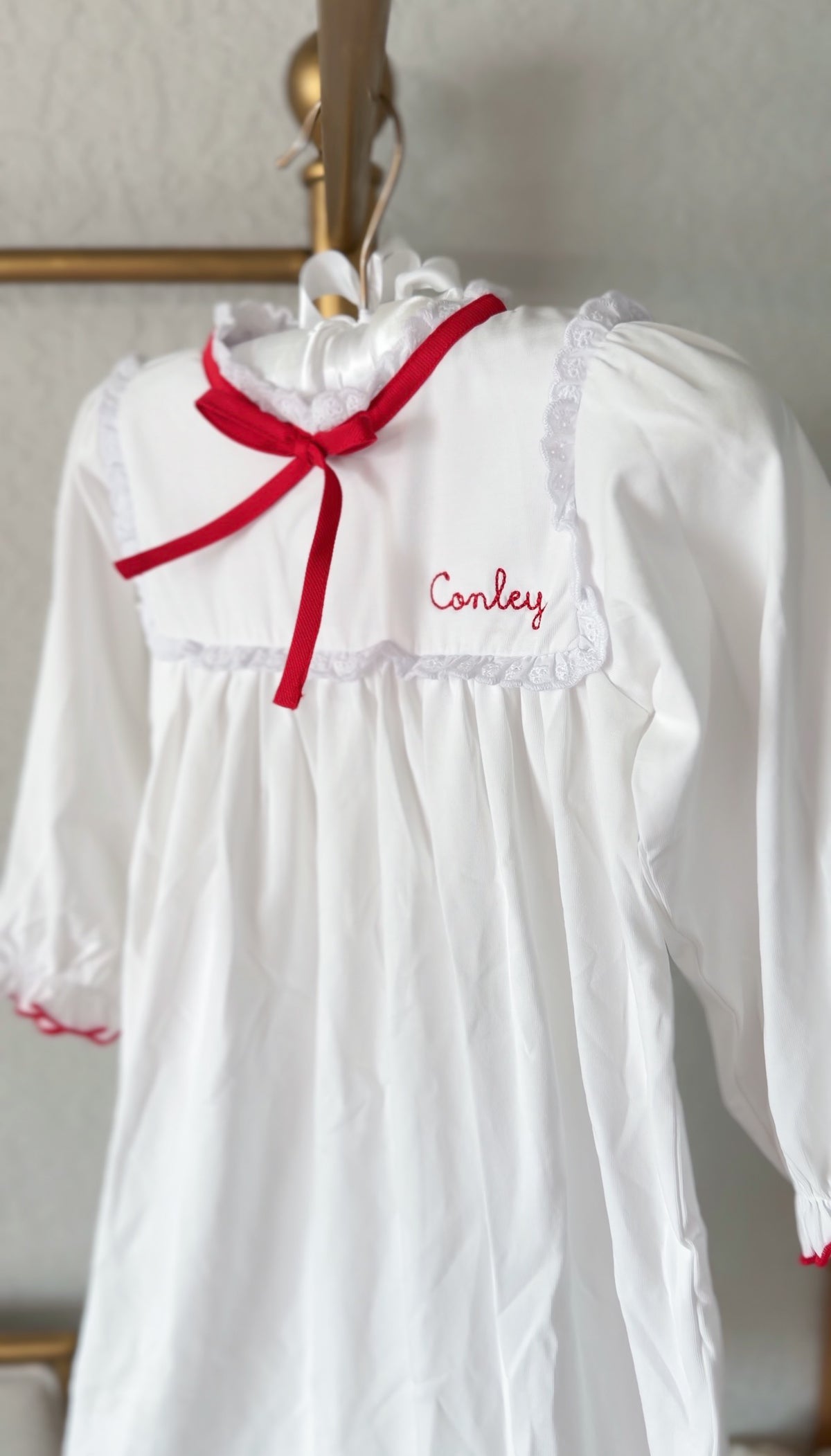White pima cotton nightgown with red trimmed cuffs and embroidered name