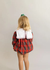 Back view of toddler in red and green plaid bubble romper with white collar