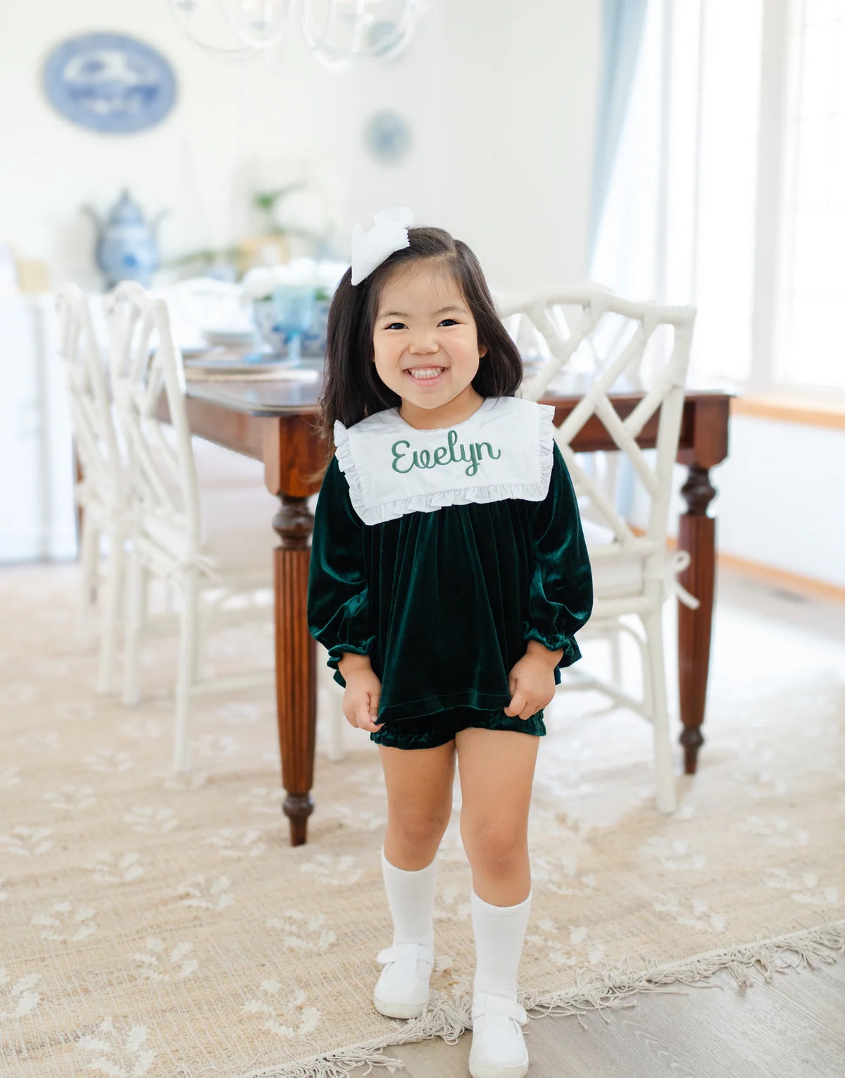 Girl in green velvet diaper set with embroidered name on white collar