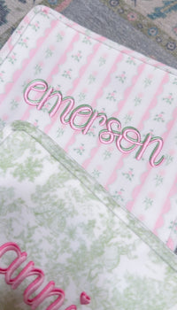 Pink ribbon floral roadie embroidered with the name Emerson