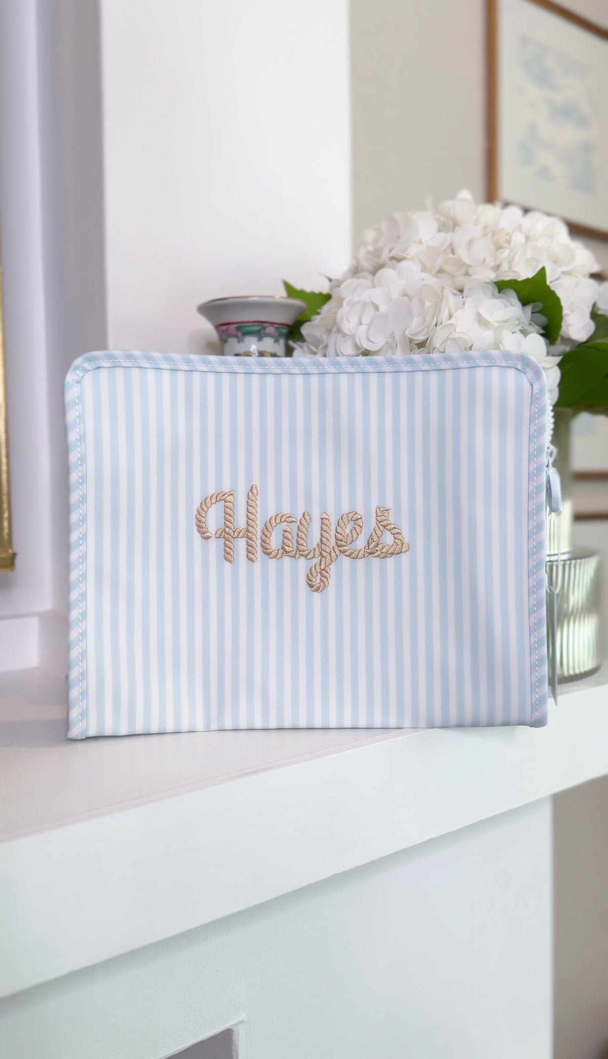 Blue and white striped TRVL Roadie pouch embroidered with 'Hayes' in gold rope-style cursive script