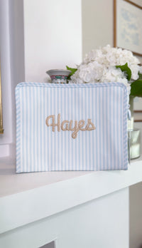 Blue and white striped TRVL Roadie pouch embroidered with 'Hayes' in gold rope-style cursive script
