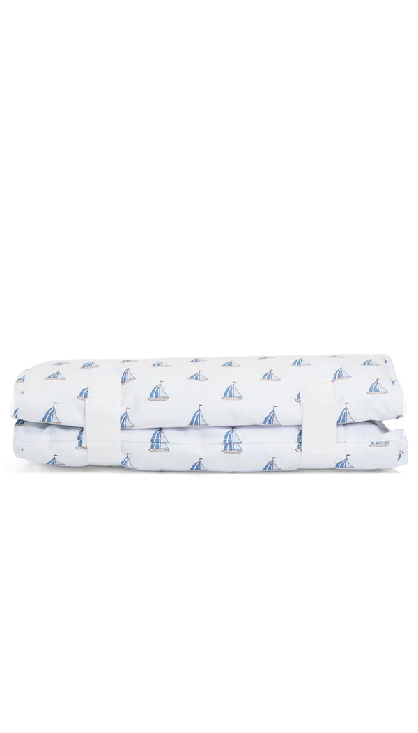 Folded nap mat with sailboat pattern on a white background