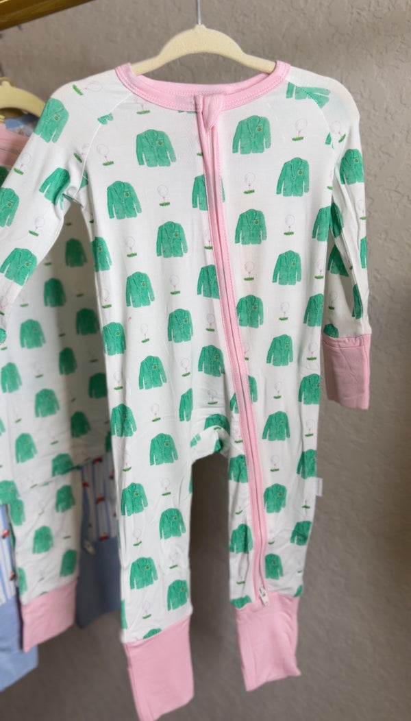Children's onesie with green coat  pattern and pink accents on a hanger against a neutral wall.