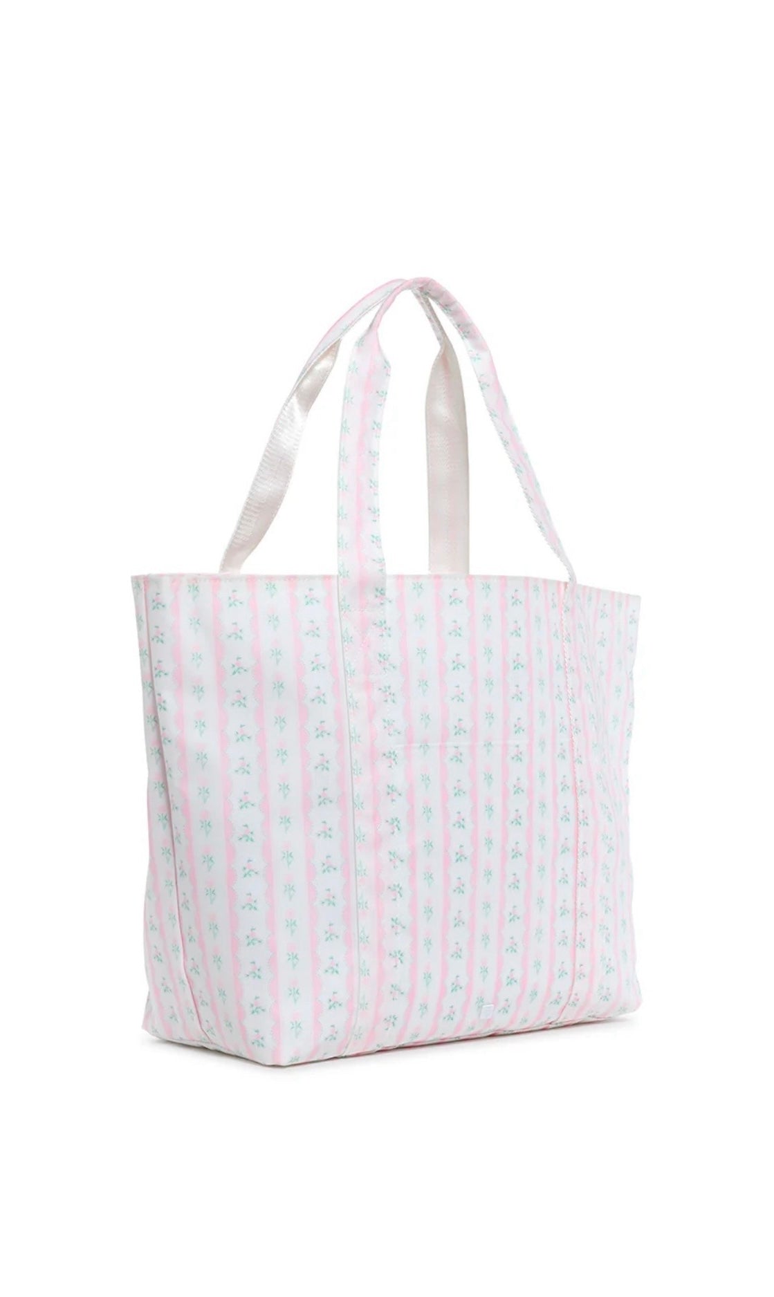 A pink floral jumbo tote bag with two handles, a front exterior pocket, and a striped pattern.
