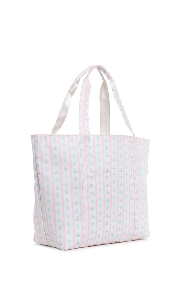 A pink floral jumbo tote bag with two handles, a front exterior pocket, and a striped pattern.