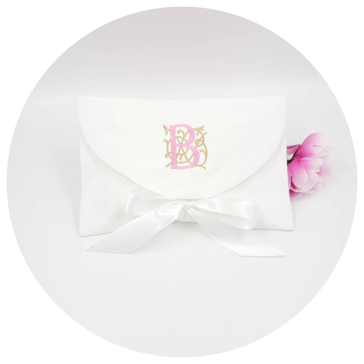 White fabric envelop with a pink flower and logo on a white background