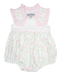 Baby romper with floral pattern and pink ruffled collar on a hanger.