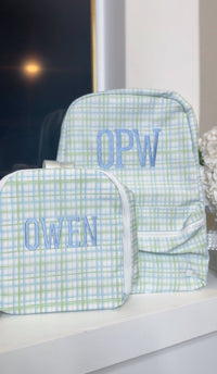 Green and blue plaid TRVL backpack and pouch embroidered with the 'OPW' monogram and the name 'Owen'