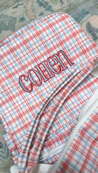 Red plaid TRVL bag embroidered with the name 'Cohen'
