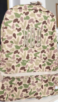 Tan and green camo duck print TRVL Backpacker embroidered with the 'WBO' monogram