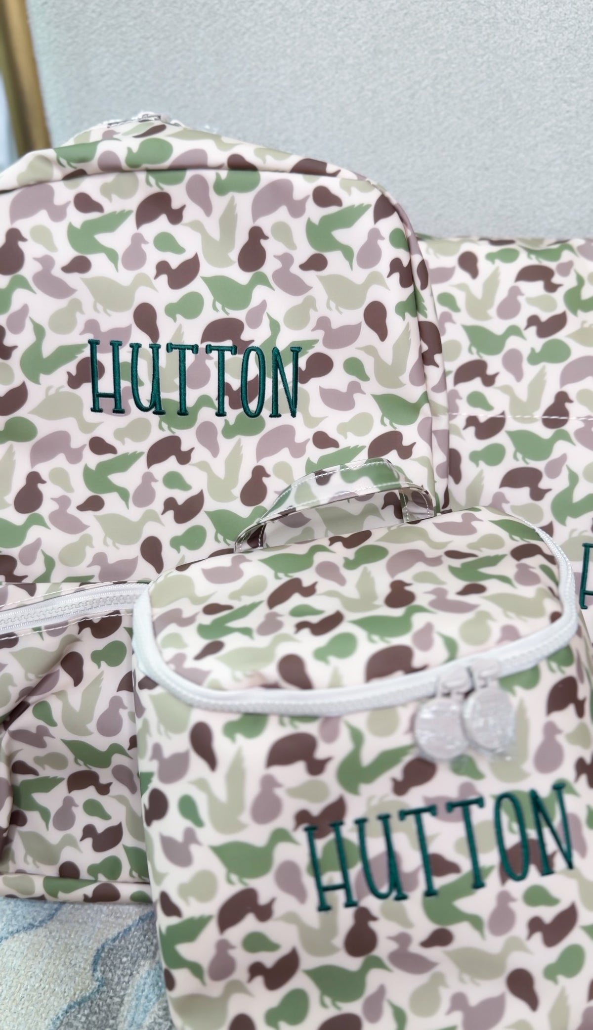 Camo duck print TRVL Backpacker and pouch embroidered with the name 'Hutton'