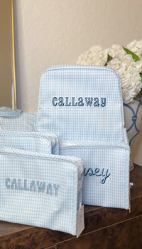 Light blue gingham TRVL Backpacker and pouches embroidered with the name 'Callaway'