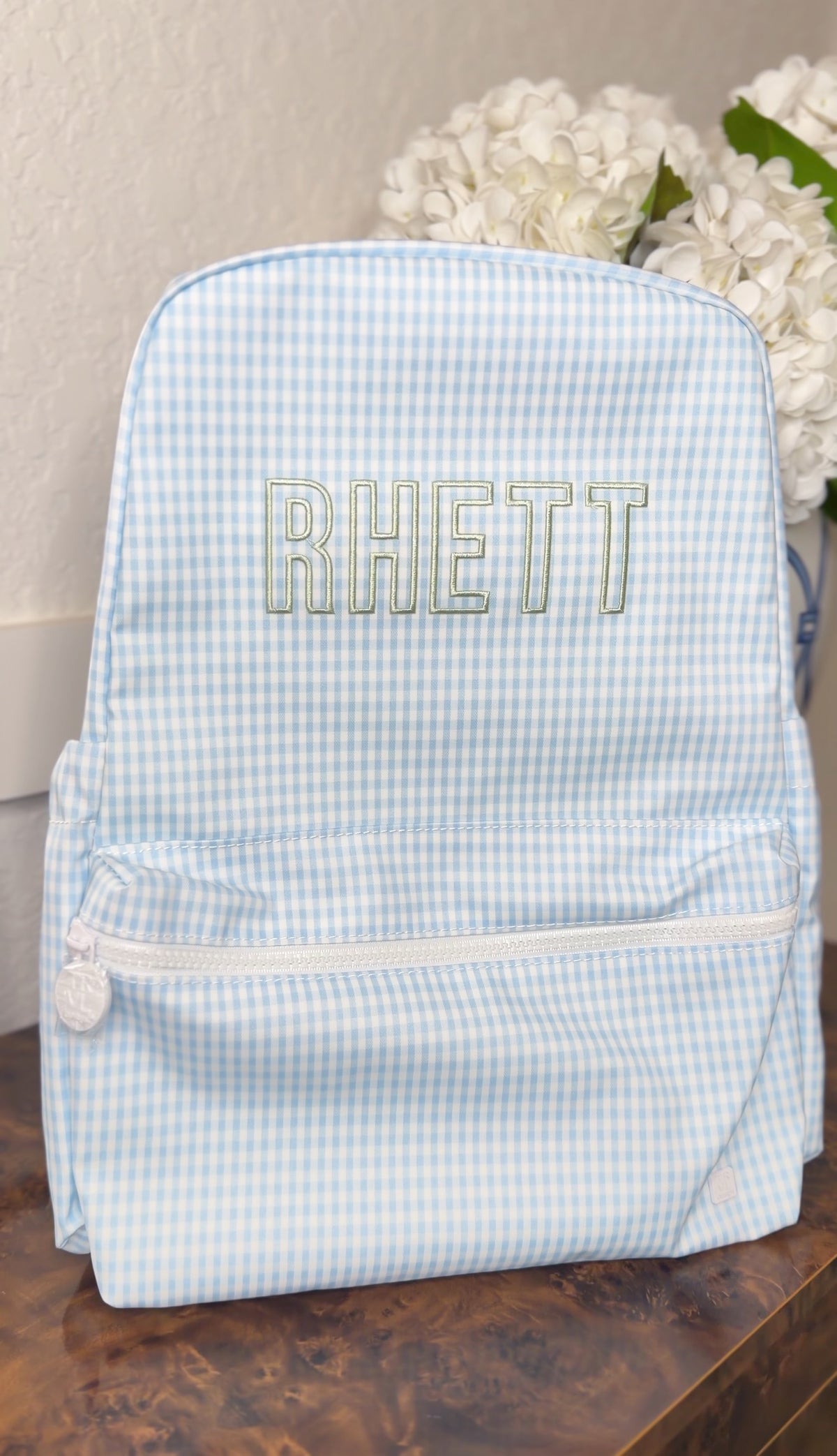 Light blue gingham TRVL Backpacker embroidered with the name 'Rhett'