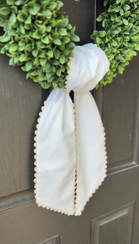 Green wreath with a white ribbon on a door