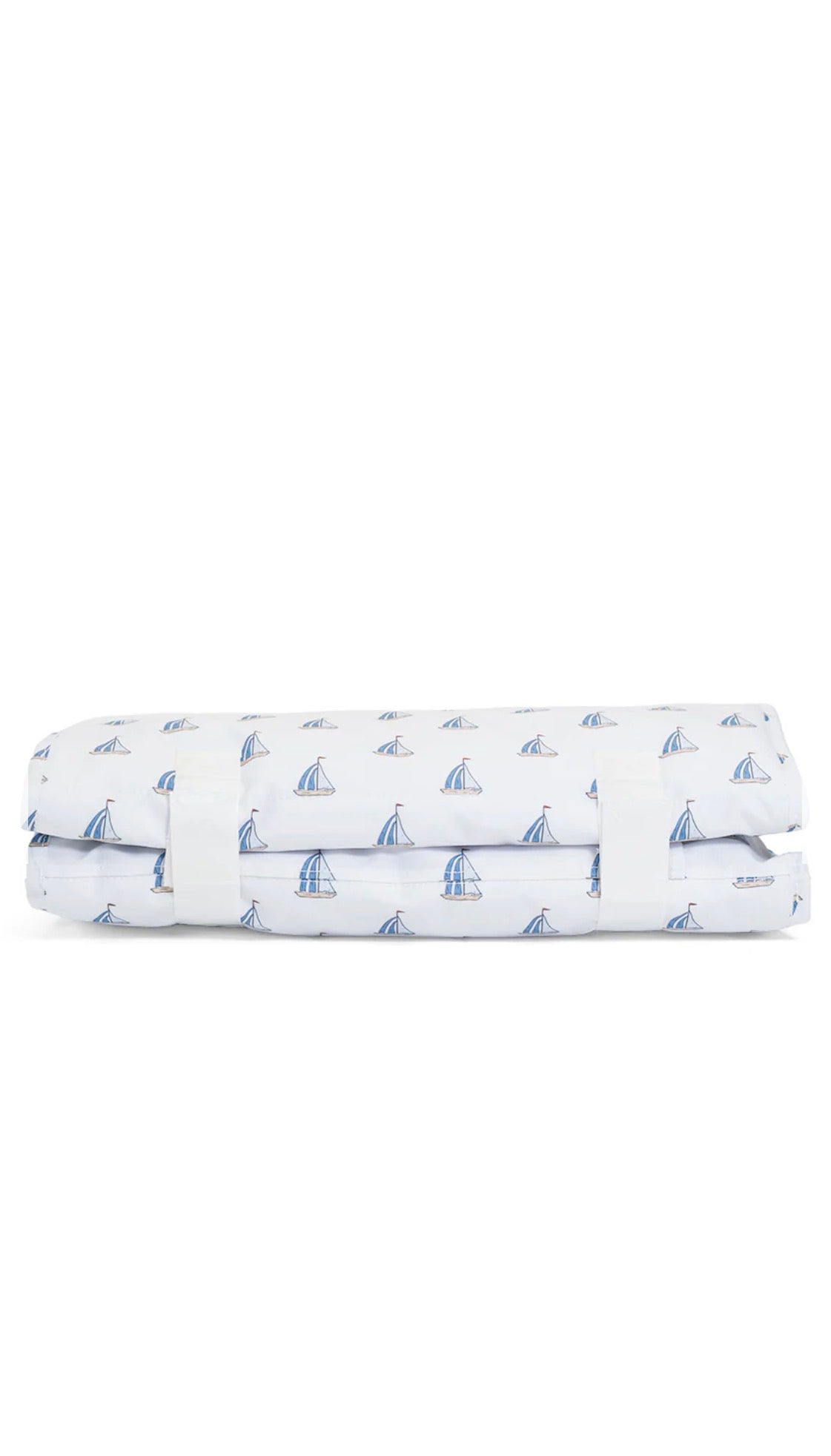 Folded nap mat with sailboat pattern on a white background