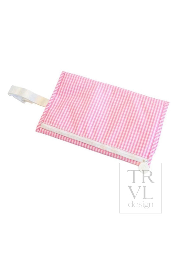 Pink gingham TRVL changing pad folded into a zippered pouch with white wrist strap