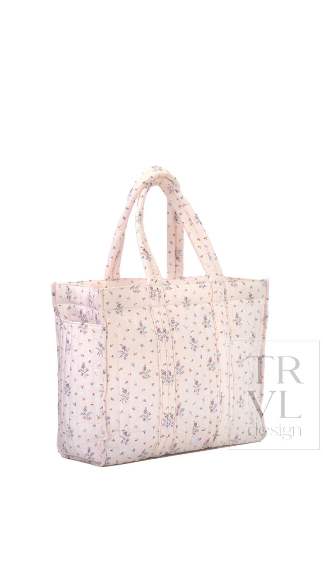 Cream quilted TRVL Go Go Tote with a small pink and blue floral print, side angle view showing exterior pocket