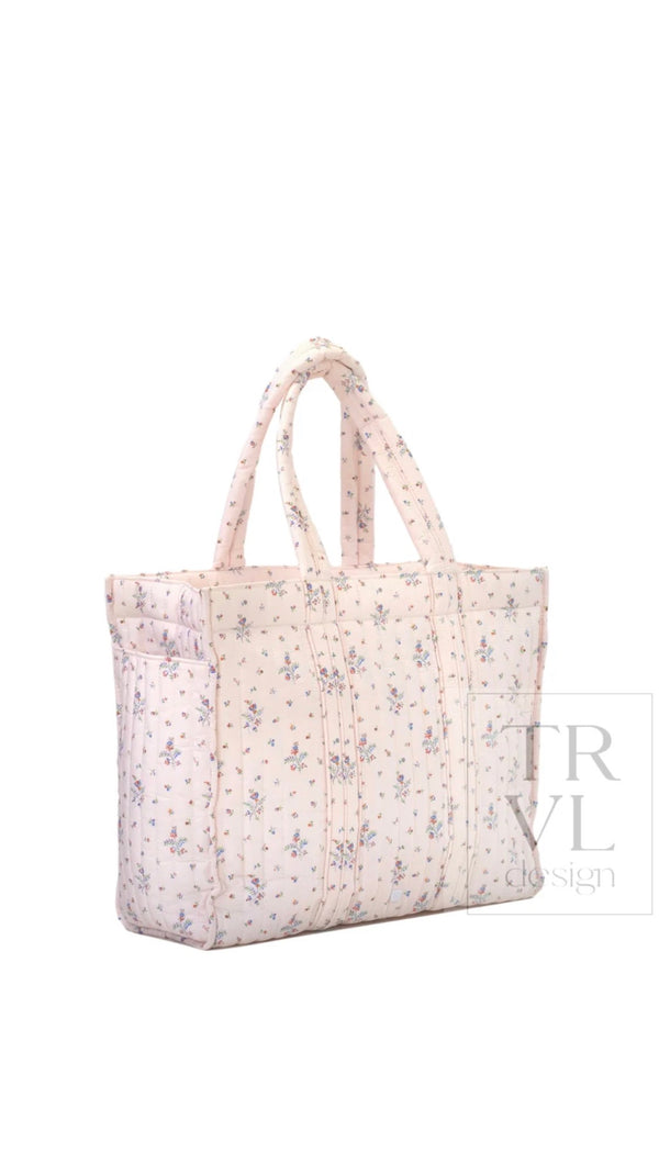 Cream quilted TRVL Go Go Tote with a small pink and blue floral print, side angle view showing exterior pocket