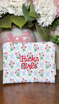 White TRVL pouch with strawberry and bow print, embroidered 'Hicks Girls' in red script