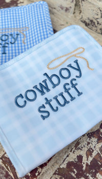 Two light blue plaid TRVL pouches embroidered 'cowboy stuff'
