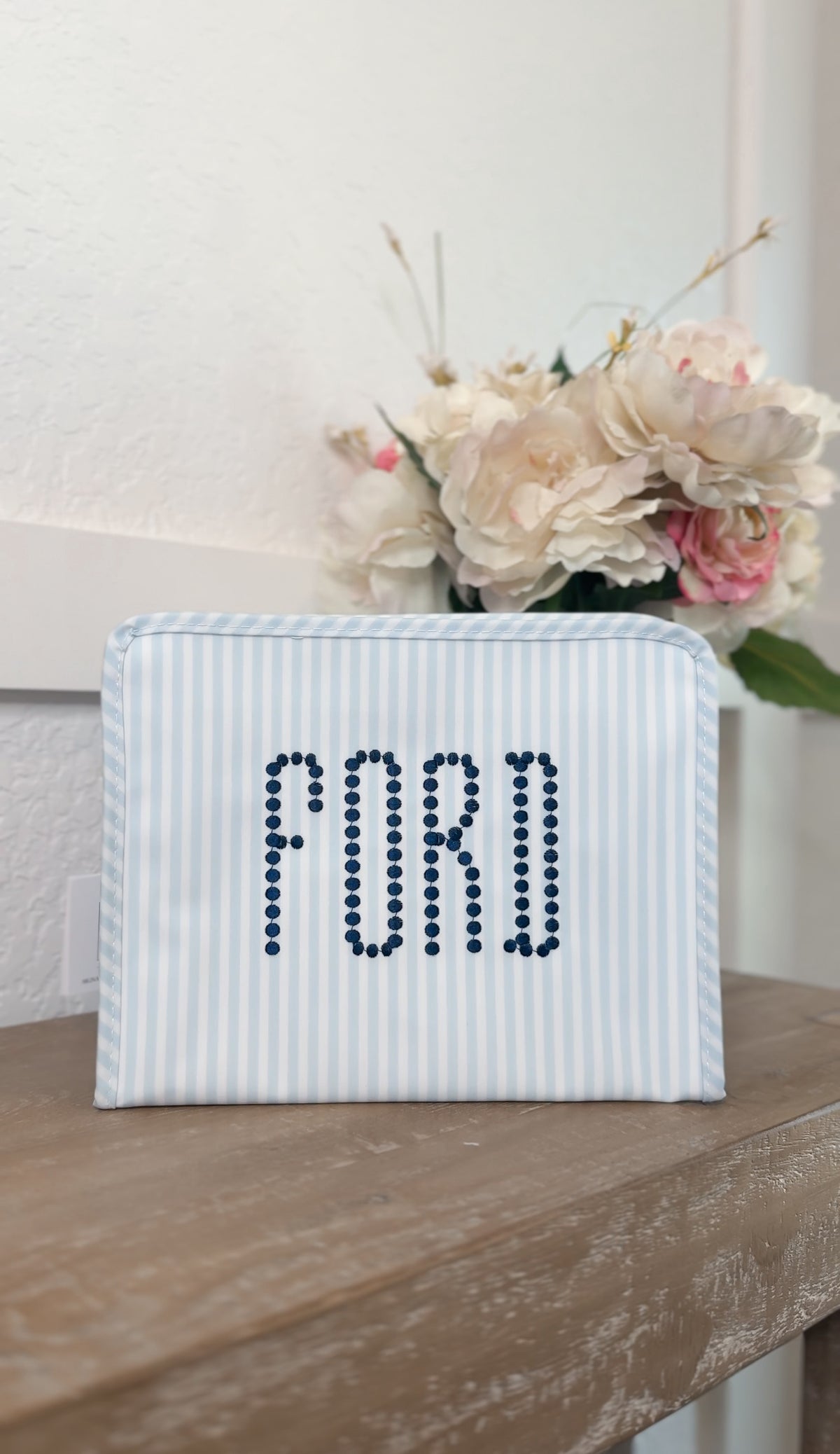 Blue and white striped TRVL Roadie pouch embroidered with 'FORD' in dotted navy lettering