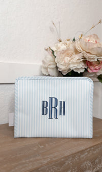 Blue and white striped TRVL Roadie pouch embroidered with 'BRH' monogram in navy serif letters