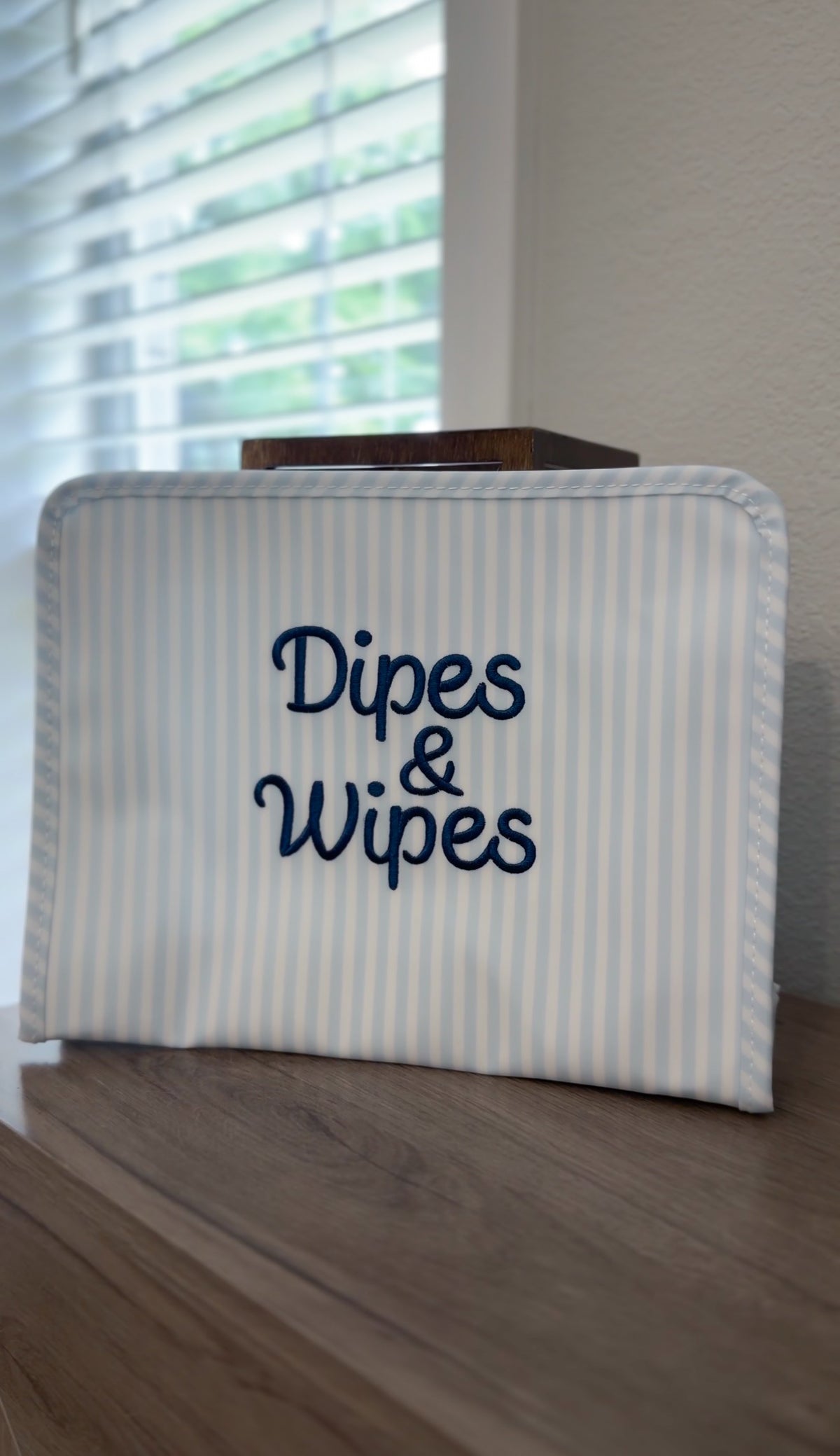 Blue and white striped TRVL Roadie pouch embroidered with 'Dipes & Wipes' in navy cursive script