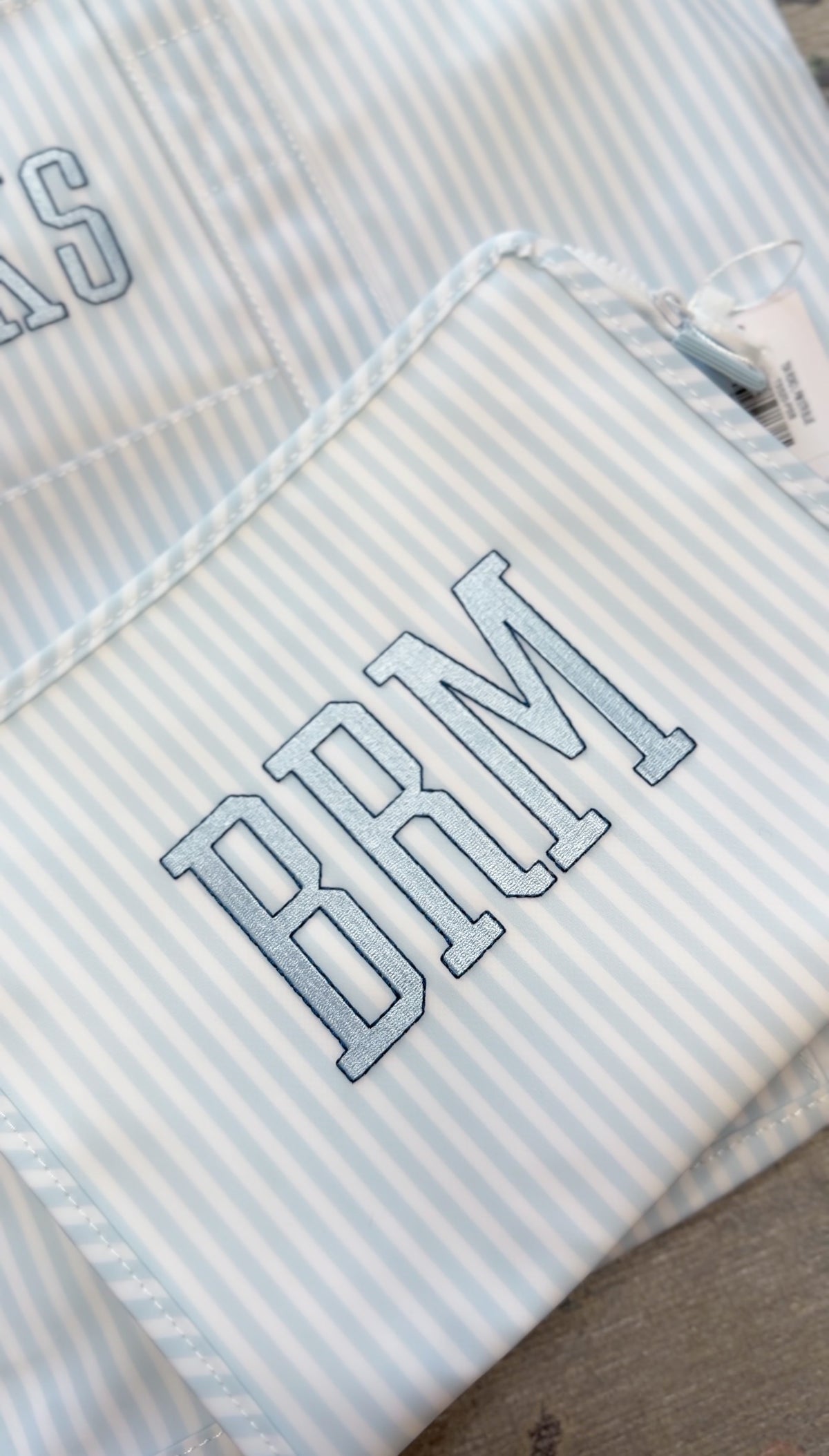 Blue Pimlico stripe TRVL Roadie pouch embroidered with 'BRM' monogram in collegiate-style letters