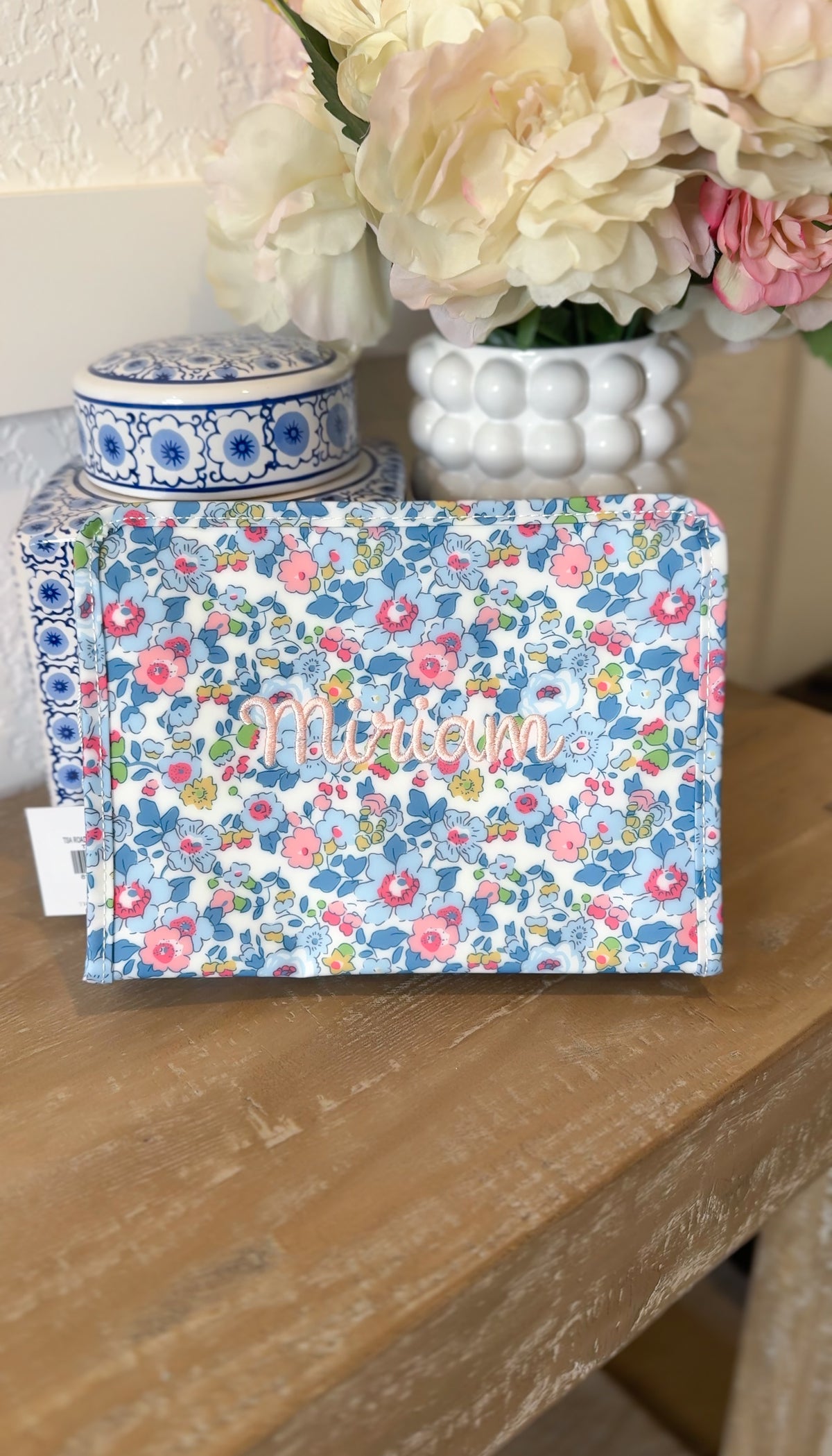 Blue floral TRVL pouch embroidered with the name 'Miriam' in pink script