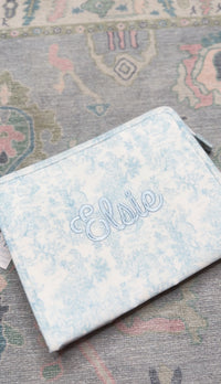 Light blue bunny toile TRVL pouch embroidered with the name 'Elsie' in matching blue script