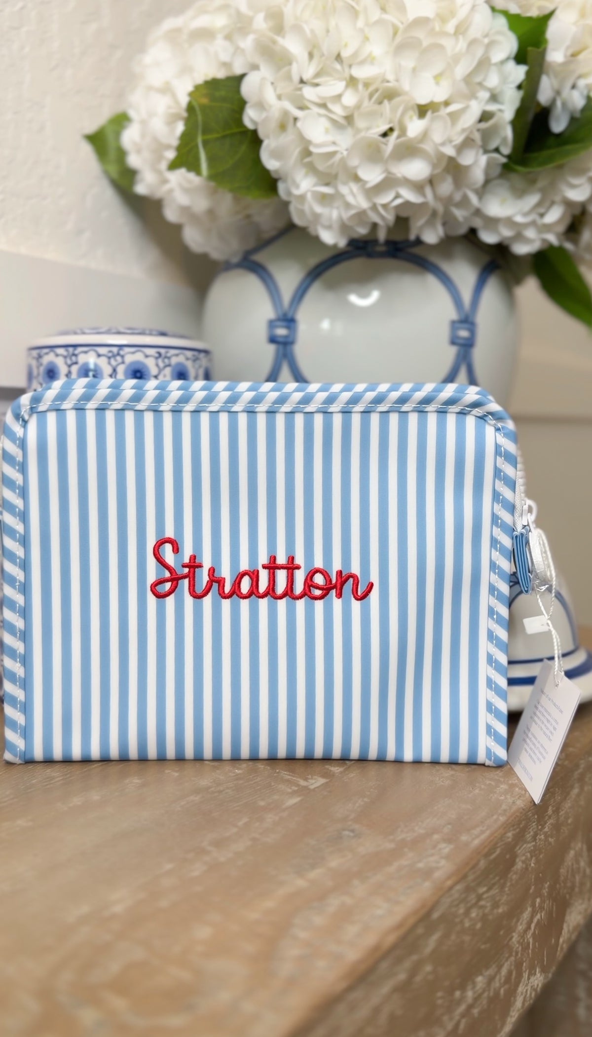 Blue chambray striped TRVL Roadie pouch embroidered 'Stratton' in red script