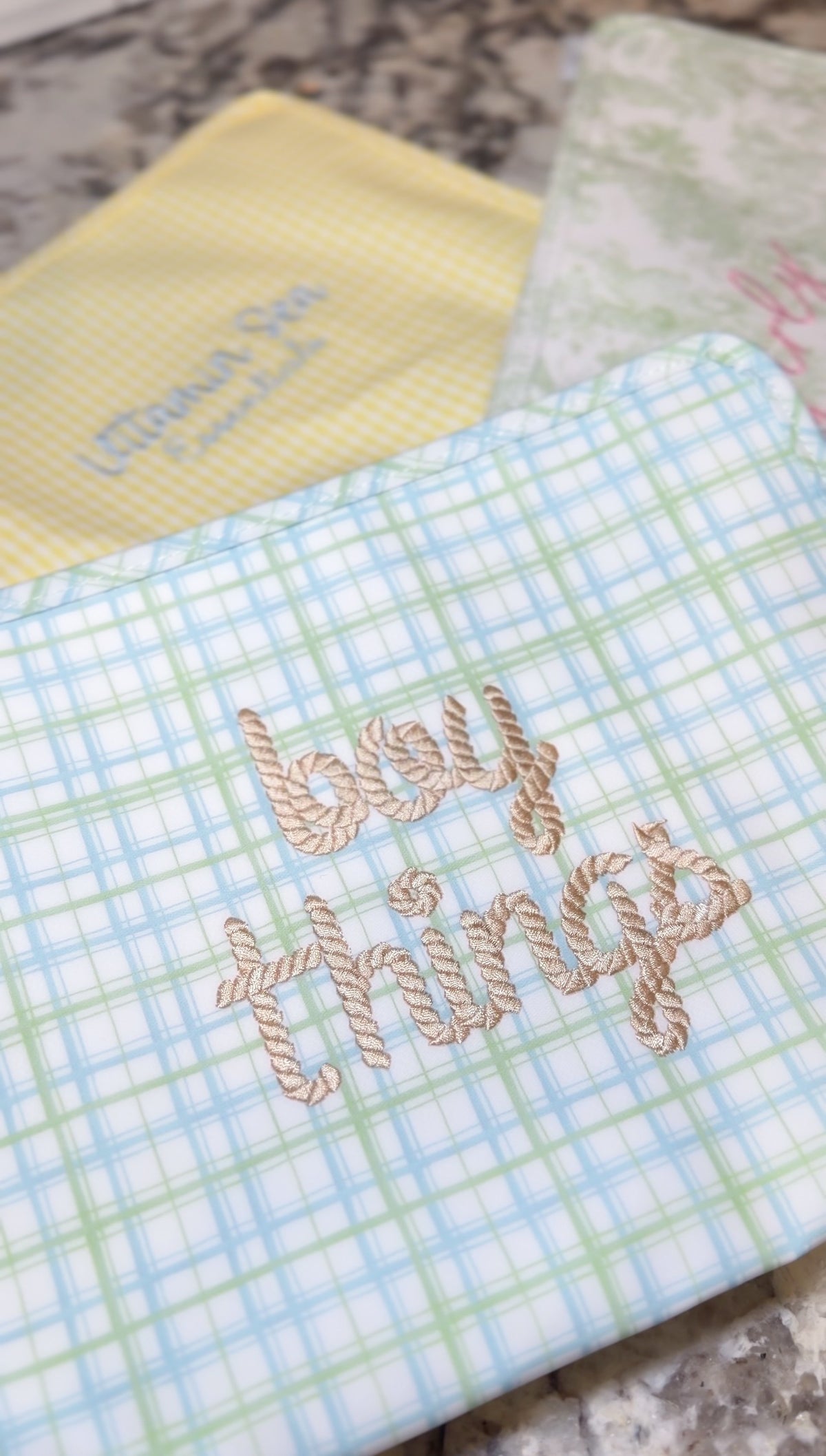 Green and blue plaid TRVL pouch embroidered 'boy things' in tan rope-style script