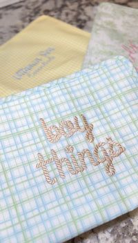 Green and blue plaid TRVL pouch embroidered 'boy things' in tan rope-style script