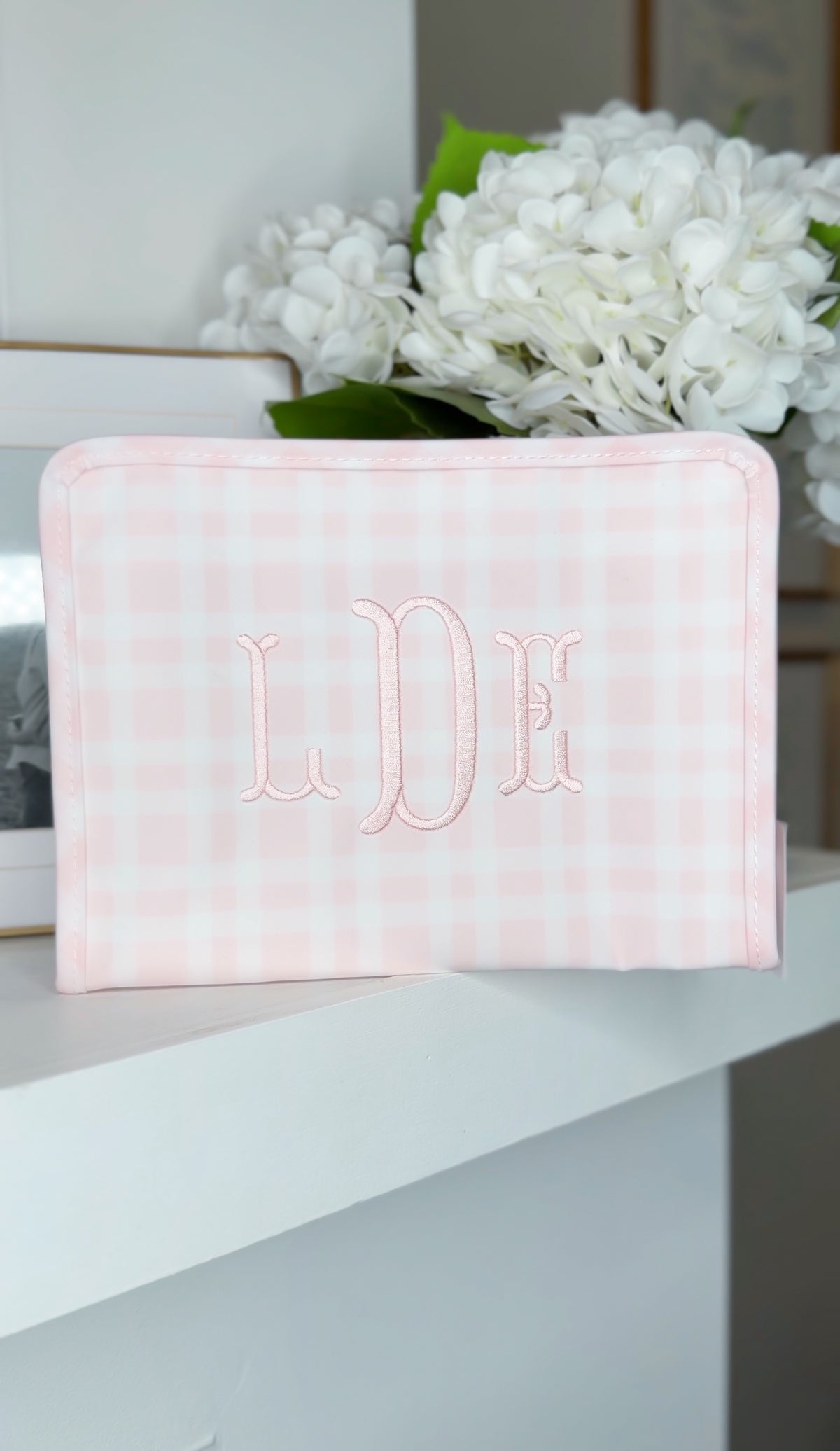 Pink gingham TRVL pouch embroidered with the 'LDE' monogram