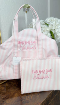 Pink Pimlico stripe TRVL Roadie pouch embroidered with a bow design and 'Valerie' in cursive script, shown with a matching tote bag