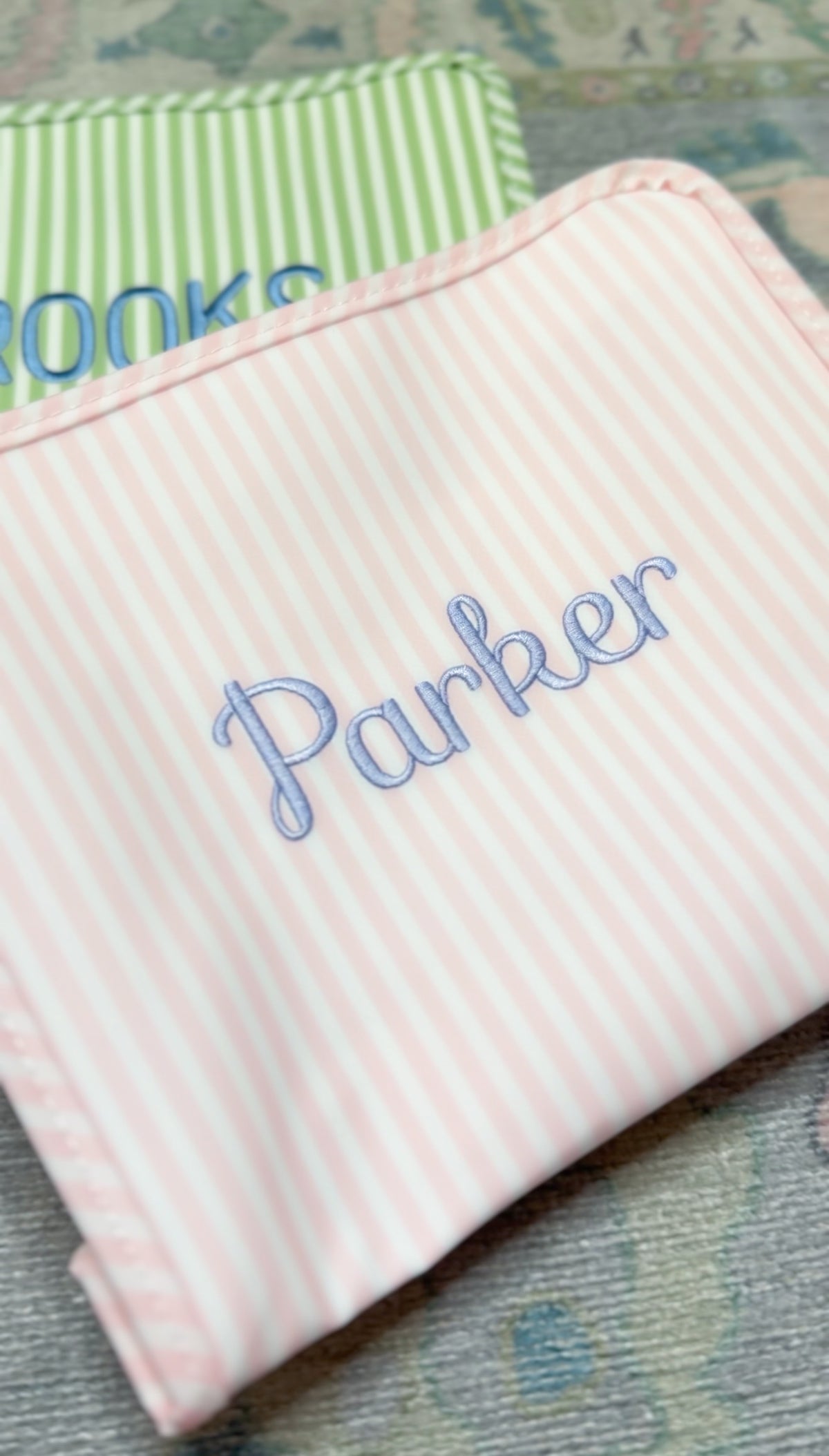 Pink Pimlico stripe TRVL Roadie pouch embroidered with 'Parker' in cursive script