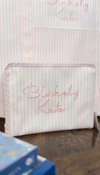 Pink Pimlico stripe TRVL Roadie pouch embroidered with 'Blakely Kate' in cursive script