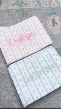 Pink and blue ribbon floral roadies embroidered with the names Evelyn and Christina
