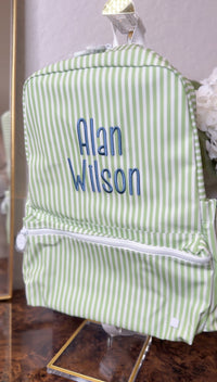 Green and white striped TRVL Backpacker on a stand, embroidered with the name 'Alan Wilson'