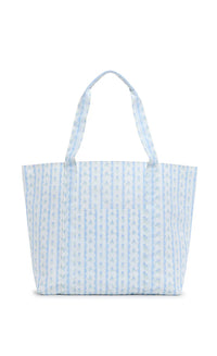 A blue floral tote bag with a structured design and satin webbing handles.