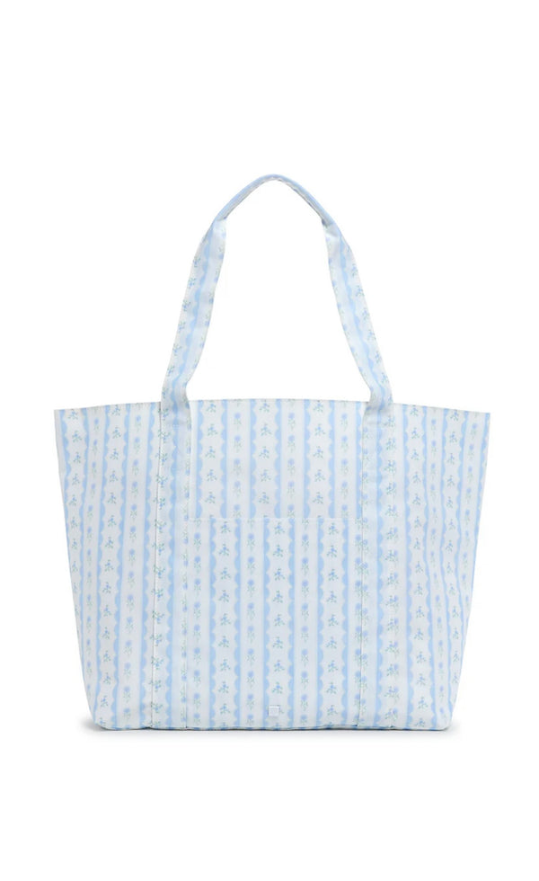 A blue floral tote bag with a structured design and satin webbing handles.