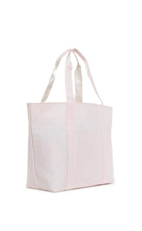 A pink striped jumbo tote bag with a top handle and a front exterior pocket, against a white background.