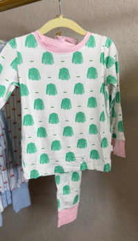 Children's pajama set with green coat pattern on a hanger against a neutral background