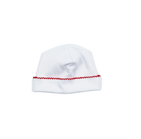 White baby hat with red trim on a white background